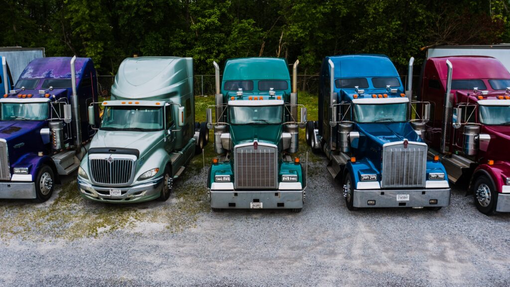 A fleet of multi-colored semi-trucks lined up in a row