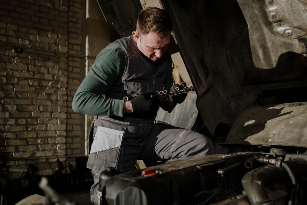 A diesel repair technician holding a bad intake manifold gasket