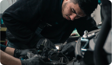 A person working inside a car and/or vehicle engine