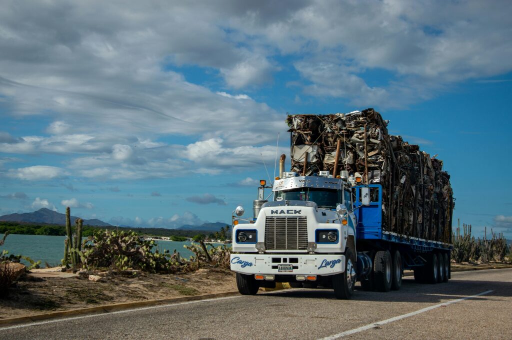 A picture of a semi truck hauling crushed parts on a flatbed near water